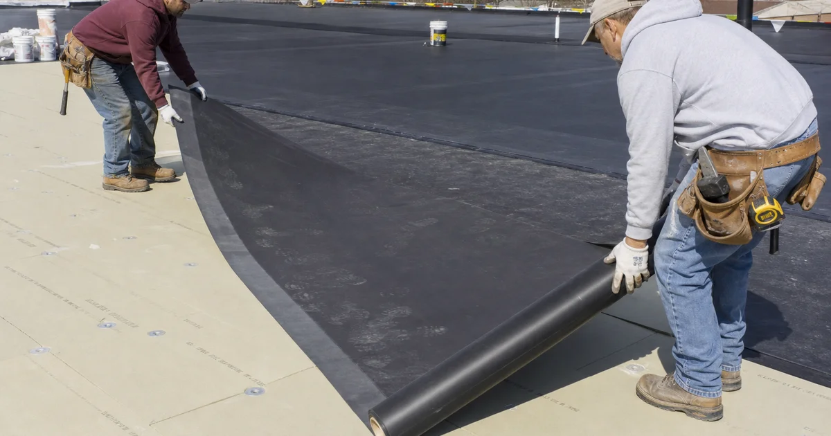 EPDM membrane being rolled out on a Hartford County commercial flat roof