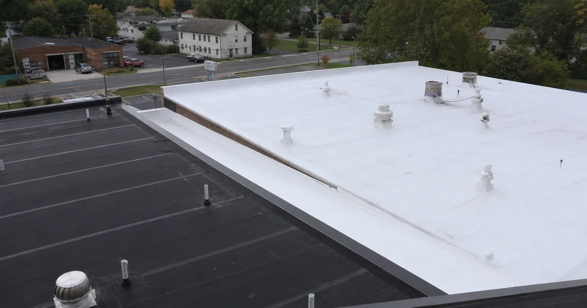 Two commercial flat roofs side by side: black EPDM and white TPO membrane